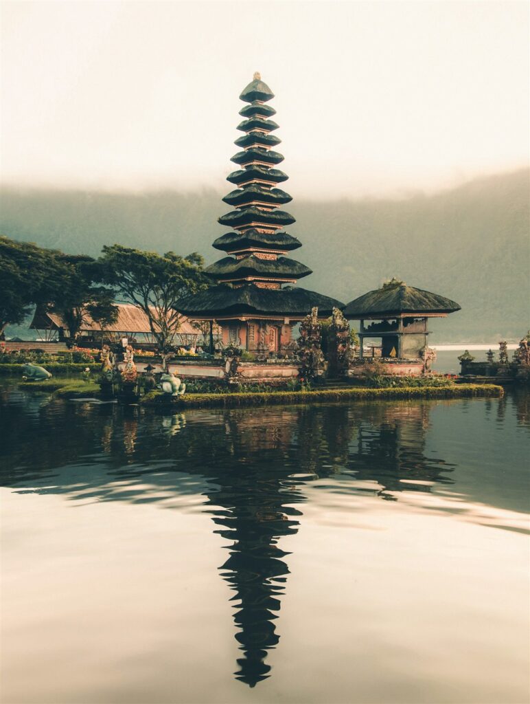 Templo balinés de varios niveles reflejado en las aguas tranquilas de un lago en Bali.